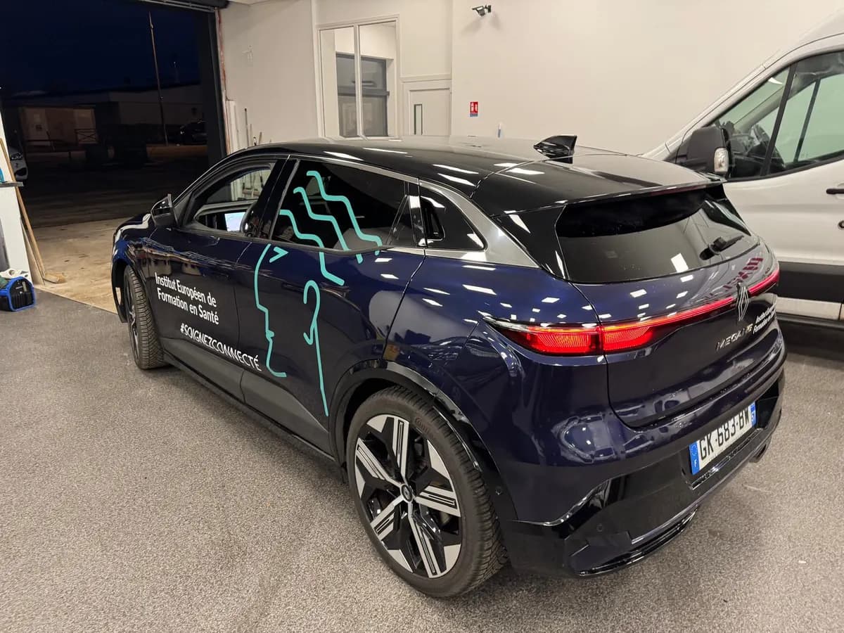Berline bleu nuit décorée d'un lettrage blanc et de motifs adhésifs turquoise découpés sur mesure