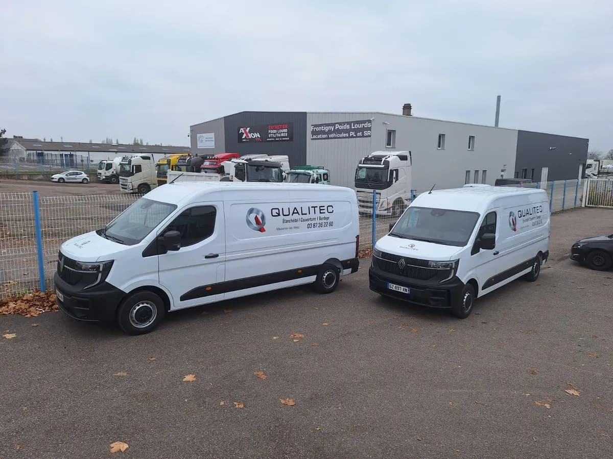 Deux fourgons blancs d'une même entreprise avec lettrage adhésif identique posé sur les flancs