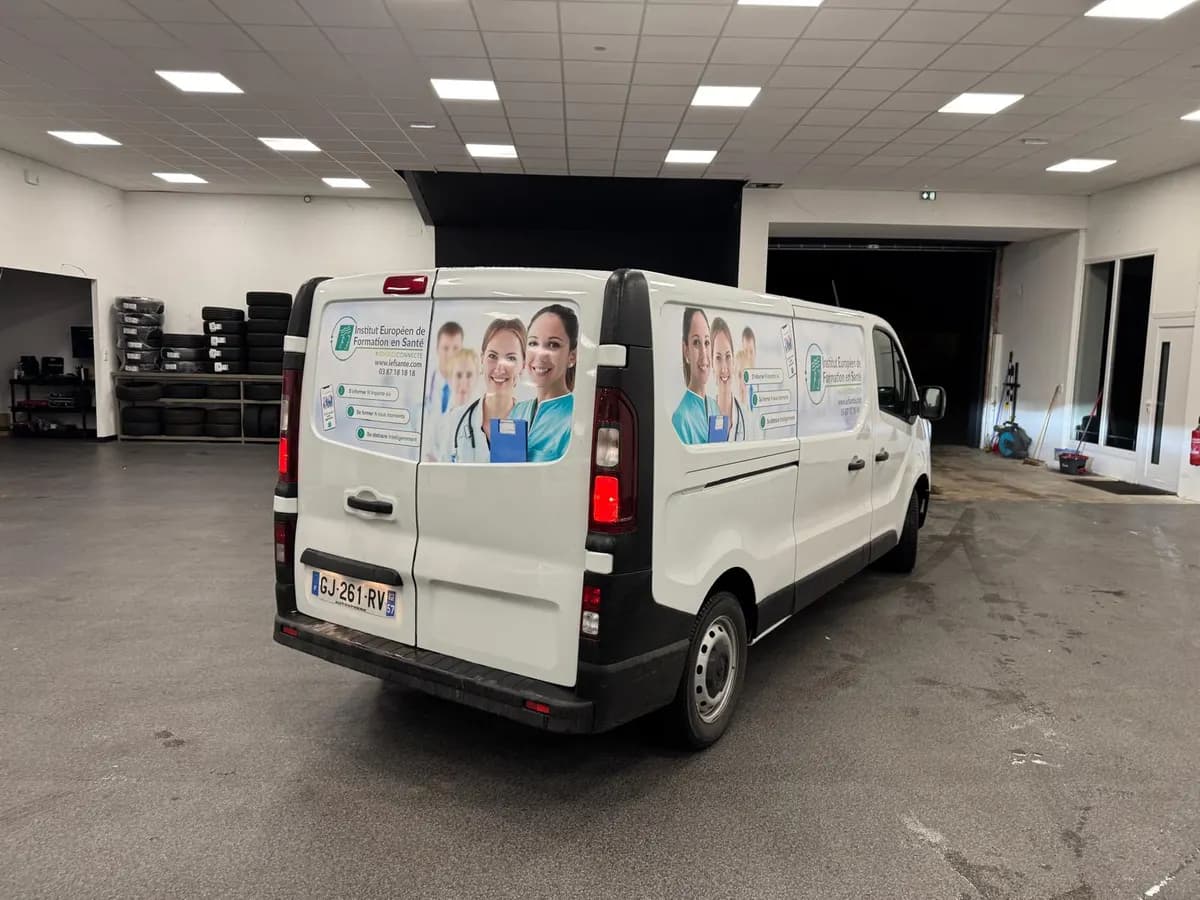 Utilitaire blanc habillé de visuels imprimés sur les flancs et les portes arrière pour un organisme de formation en santé